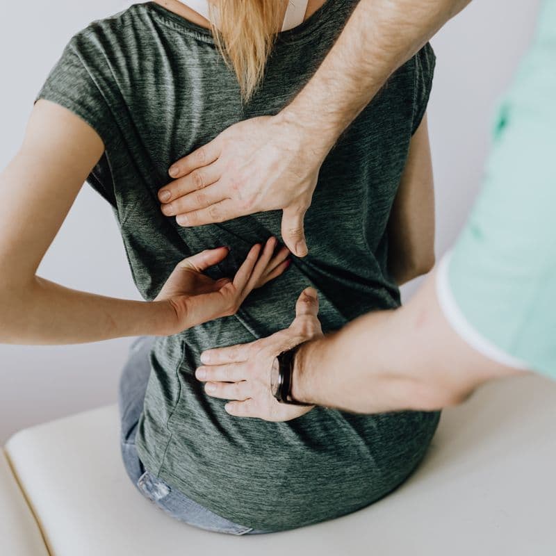 Clinician assessing a patient's back and joints